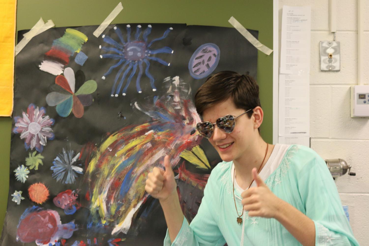 Thomas Jackson, in his Spirit Week garb, shows off artwork done for a Woman of the Week activity