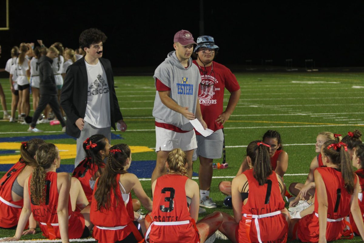 Coaches (left to right) Dan Diamond, Cooper Shelton, and Kyler Snow prep the senior team during halftime. 