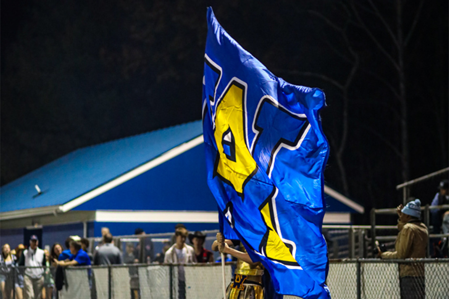 Warrior mascot Max Weaver waves the school banner at the last game of the season - and the first to be secured by the new scanners.