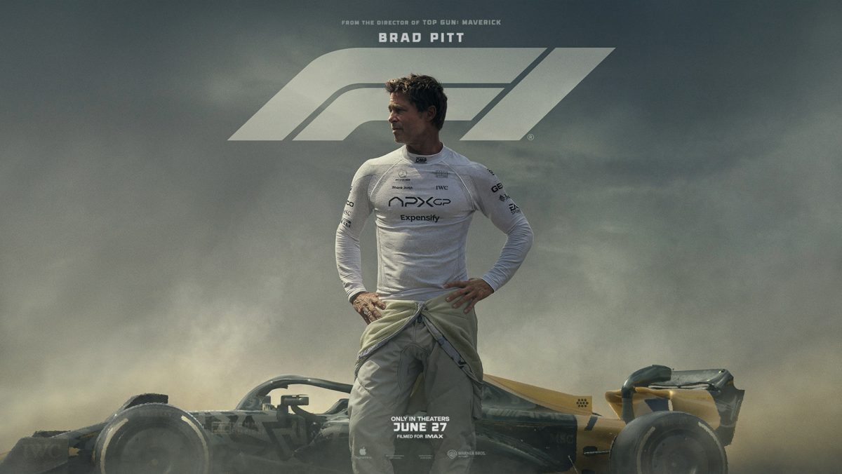 Brad Pitt (center) in his racing gear, is outside of his F1 car as depicted in the image.